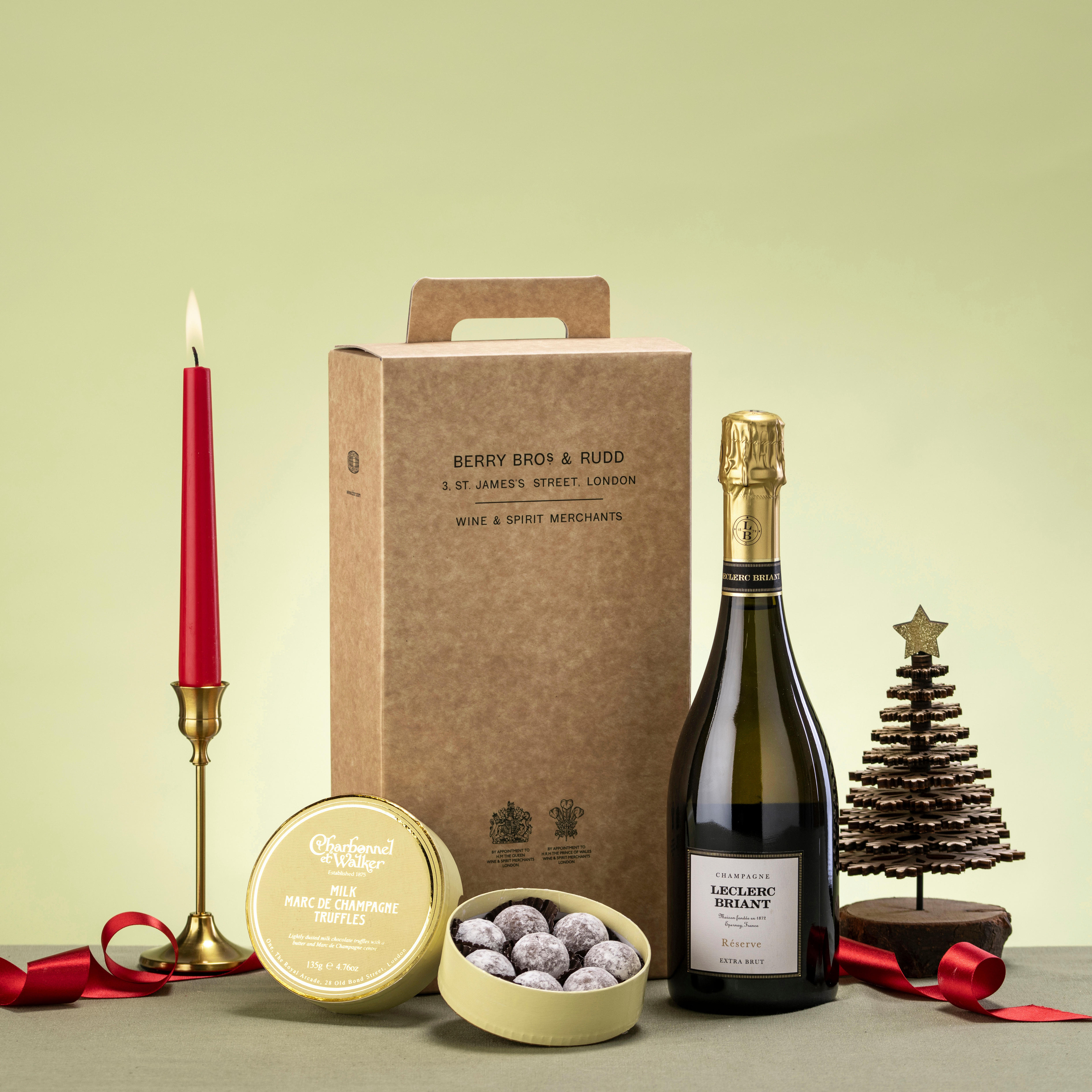 A festive giftbox with a bottle of sparkling wine and chocolate truffles. 