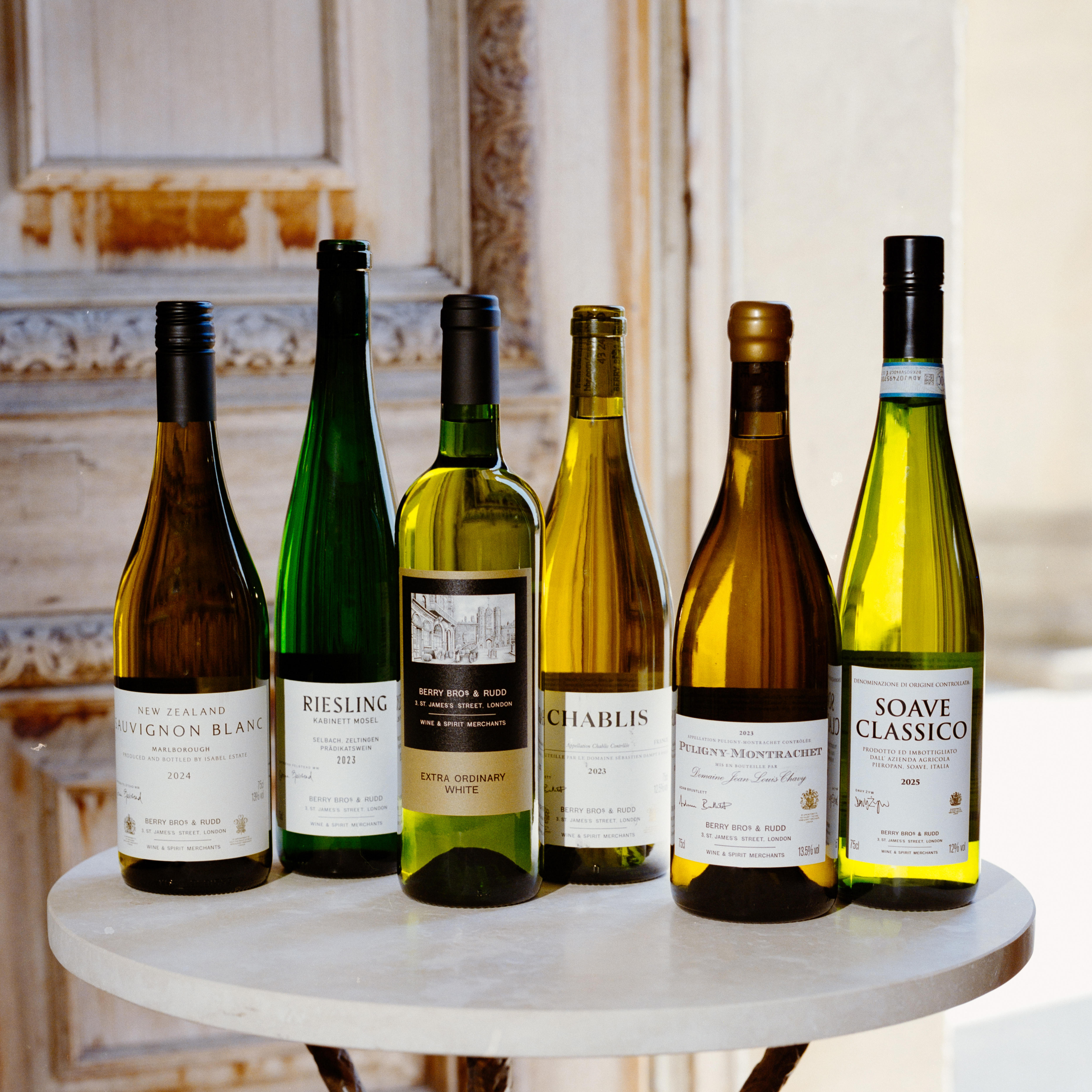 Berry Bros. & Rudd Own Selection wines displayed on a marble table in a softly lit room.