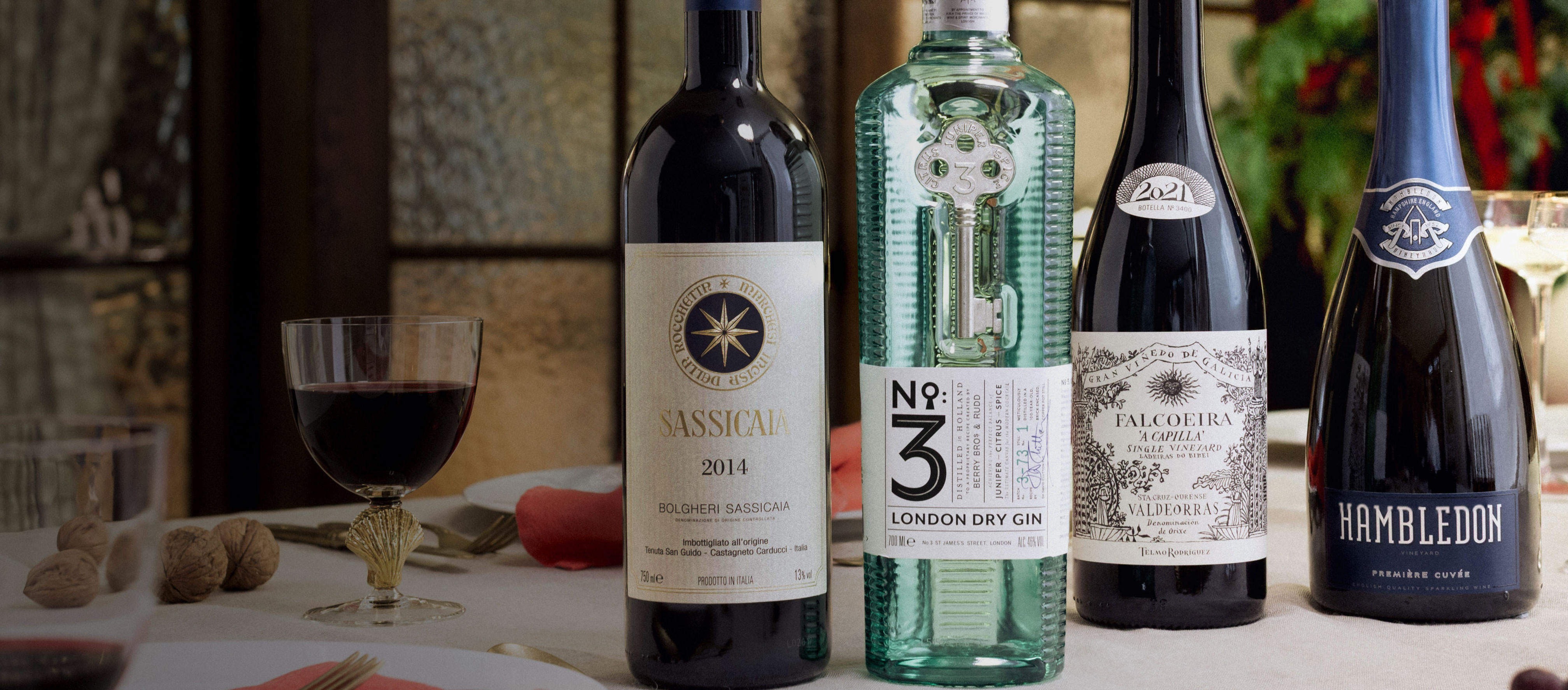 A selection of red and Champagne bottles and a No. 3 gin bottle against a festive background. 