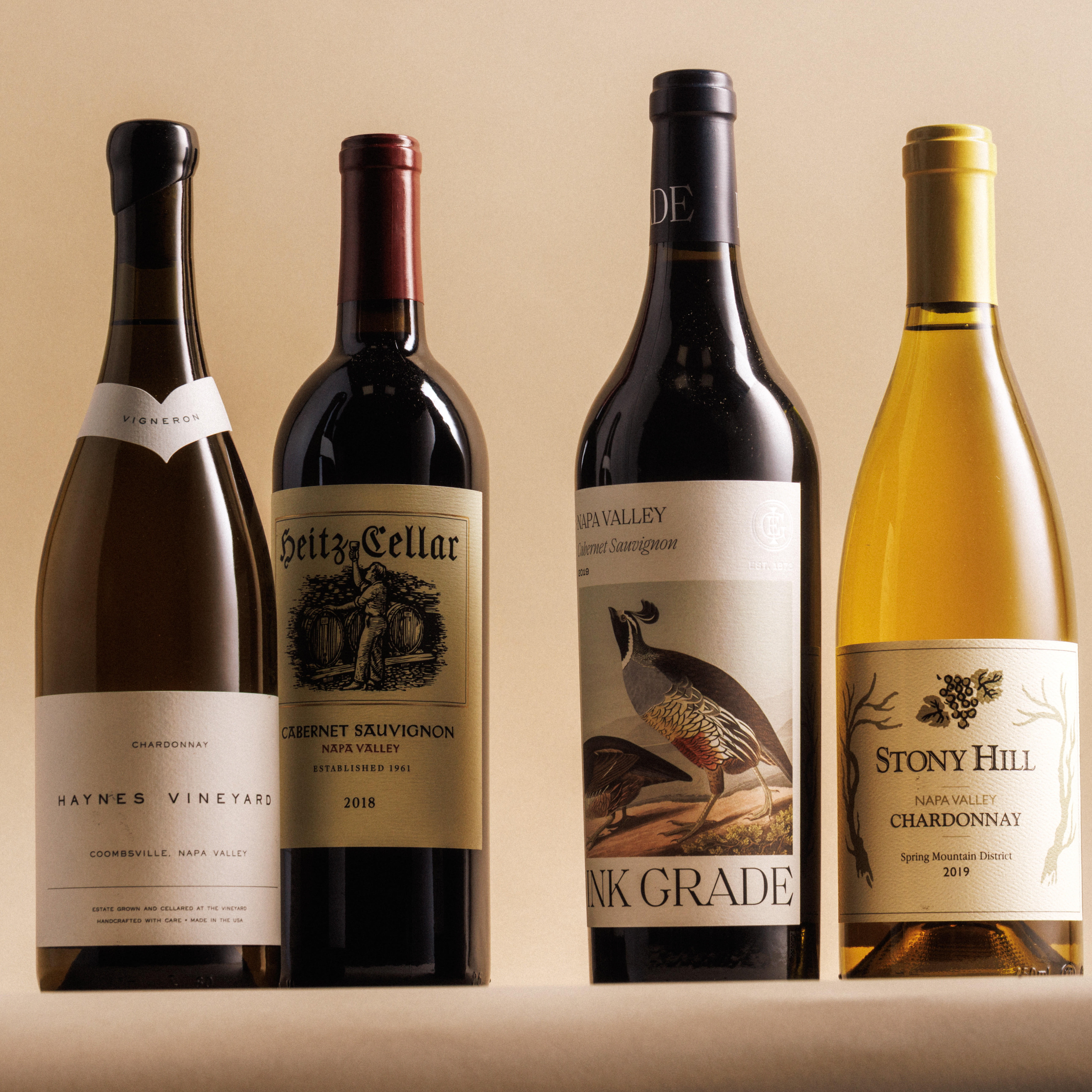 4 bottles of wine from Napa Valley against a tan background. 