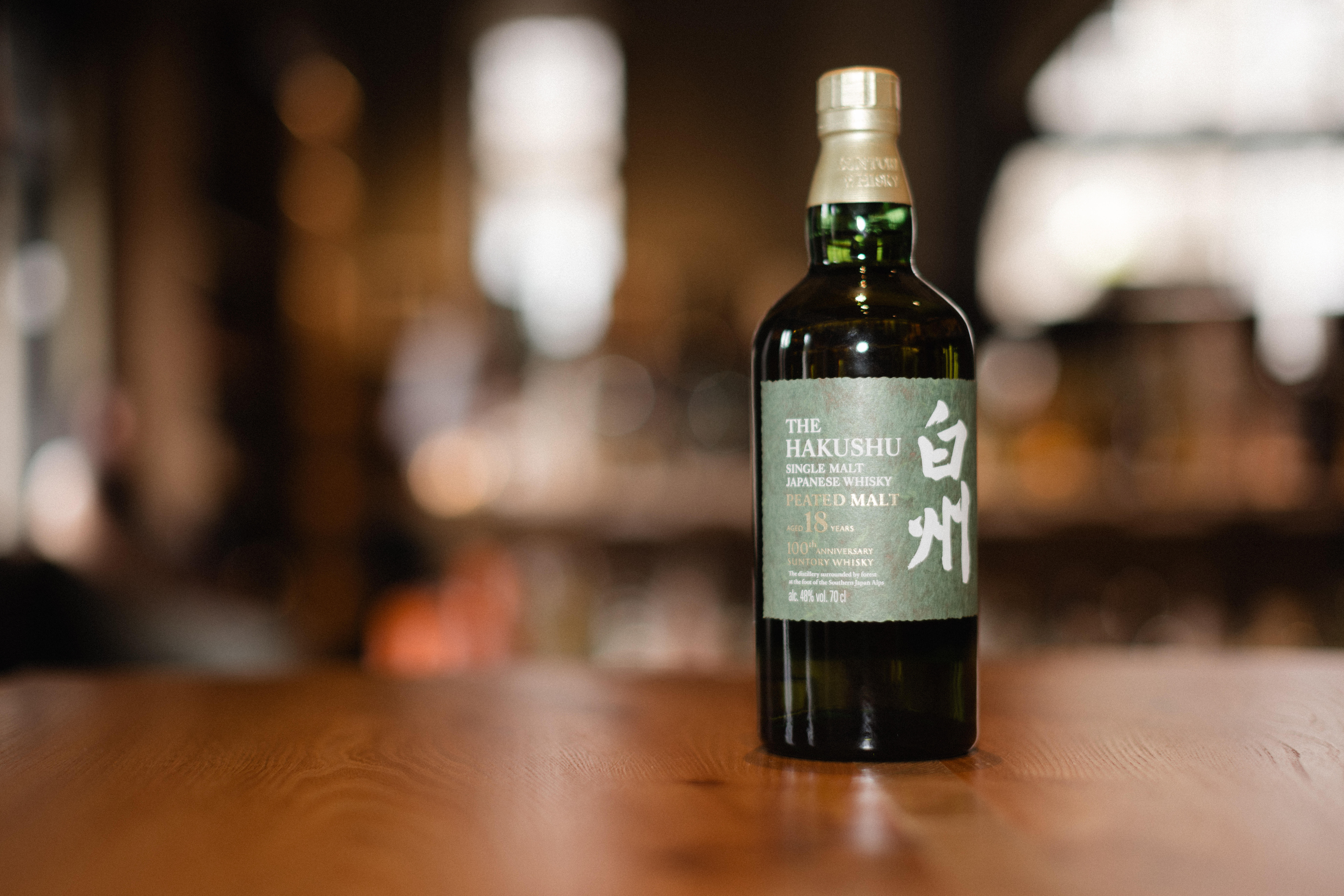 A bottle of Yamazaki 12-Year-Old Single Malt Japanese Whisky on a wooden surface with a blurred background
