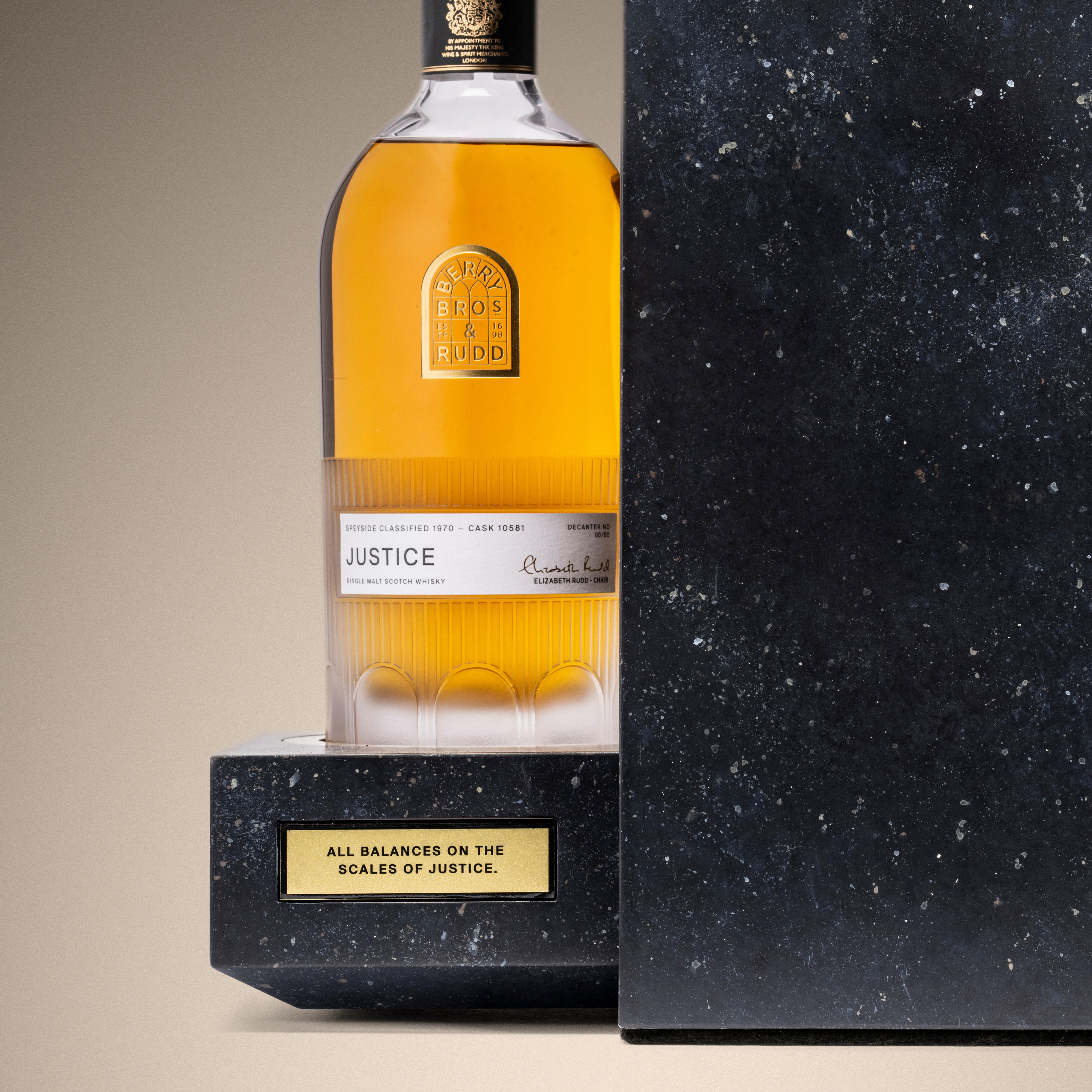 Justice whisky decanter from Berry Bros. & Rudd’s The Duel set, displayed on a stone-textured plinth.