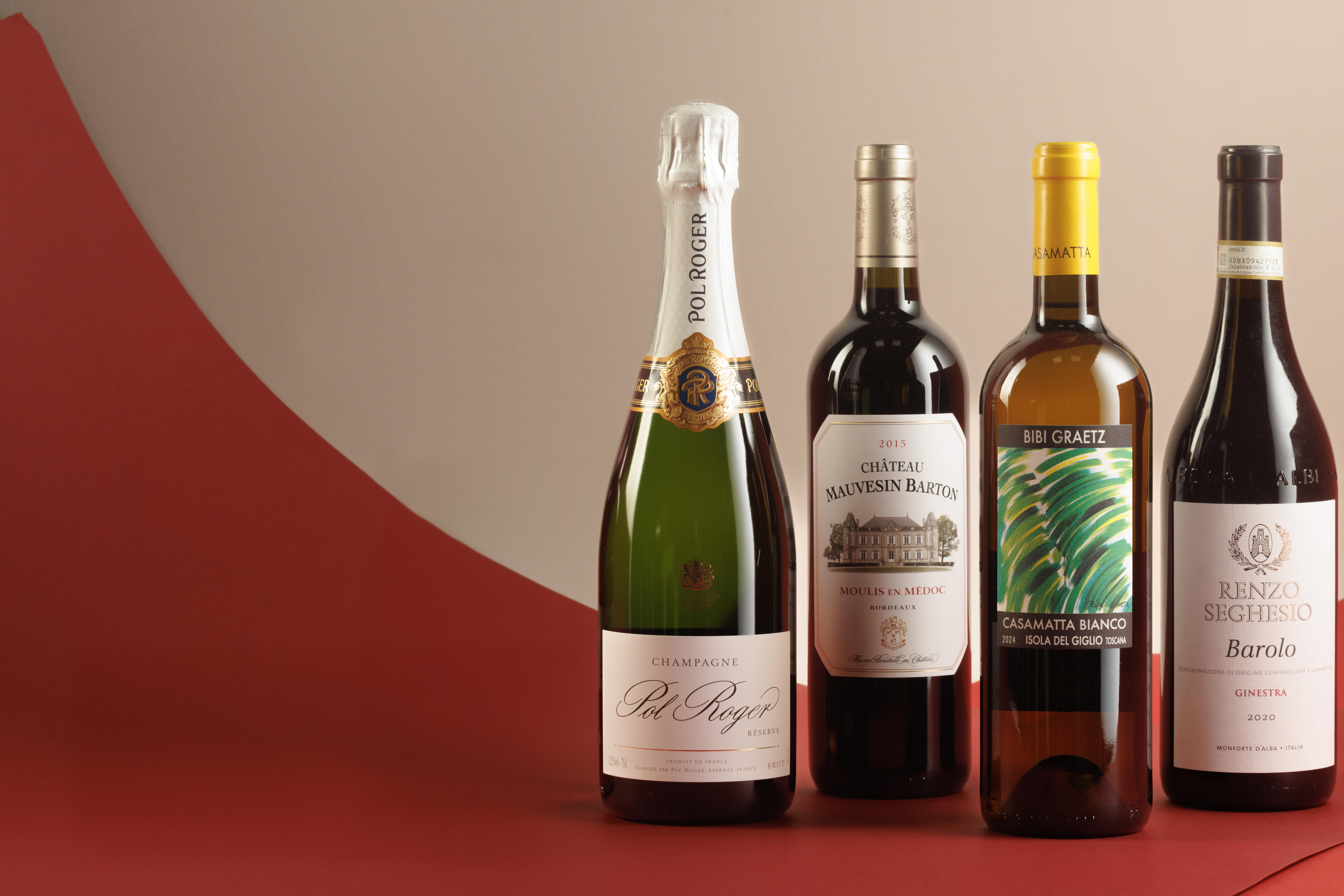 Pol Roger, Bordeaux, Bibi Graetz, and Barolo bottles all lined up against a red and white background. 