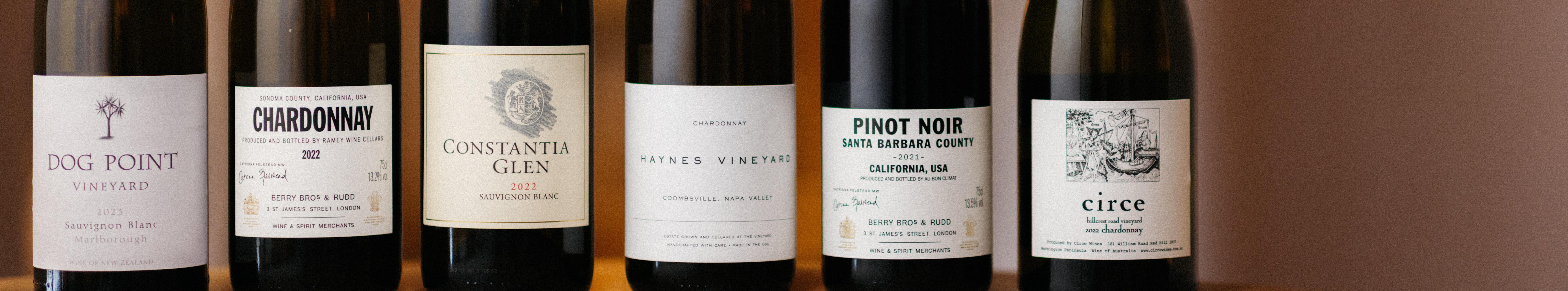 Five wine bottles from Berry Bros. & Rudd, featuring Sauvignon Blanc and Chardonnay from regions including Marlborough, Sonoma, and Napa Valley.
