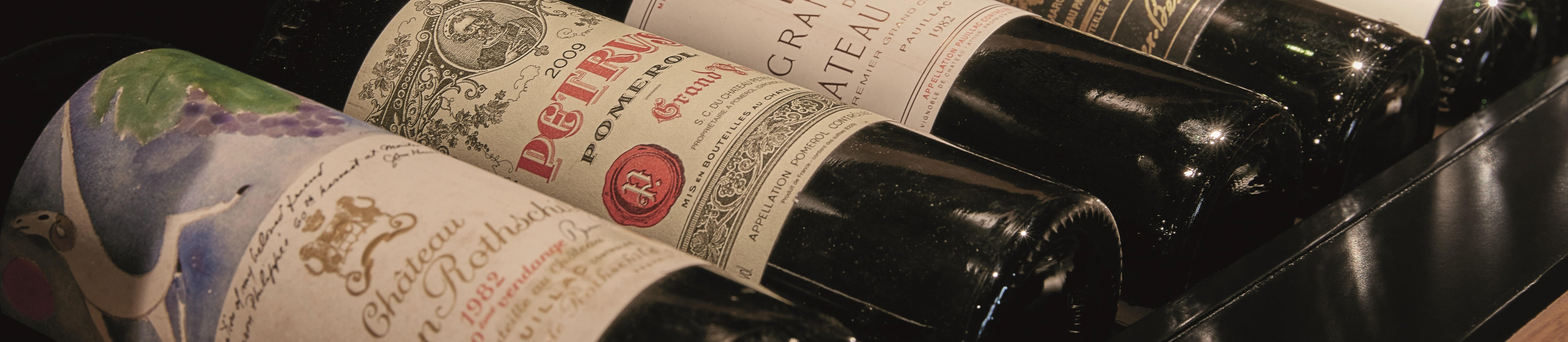 A selection of mature fine wine bottles, including Château Lafite Rothschild and Petrus, aged to perfection in Berry Bros. & Rudd’s cellars.