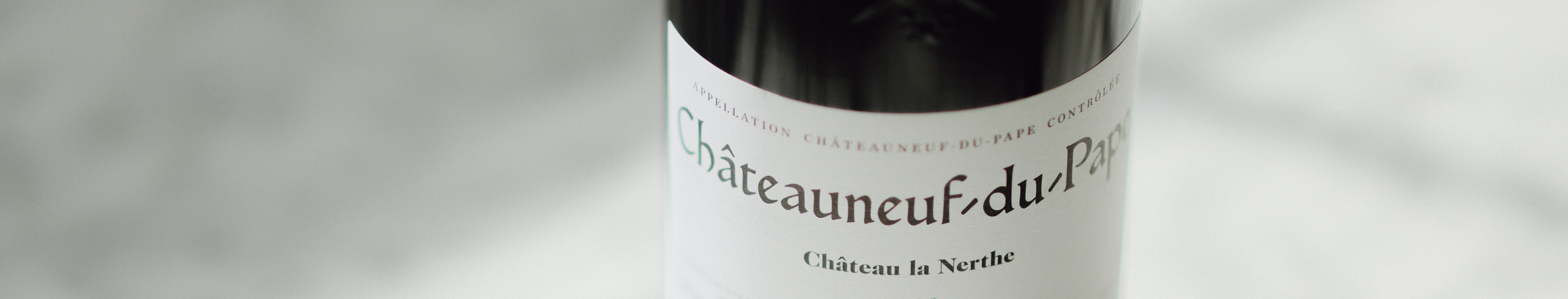 Close-up of a Berry Bros. & Rudd Own Selection wine bottle from the Rhône region. The label shows the word ‘Châteauneuf’ in large serif font, with part of the appellation text visible against a soft grey background.