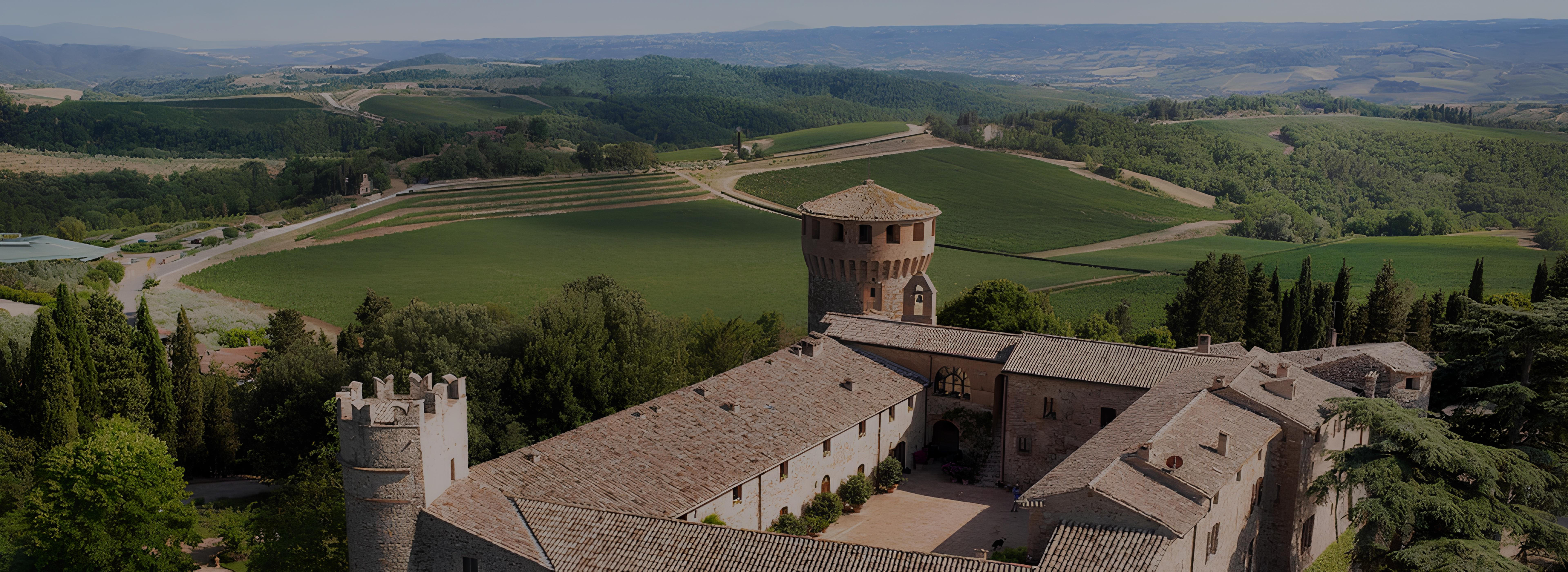 Castello della Sala, the historic Marchesi Antinori estate in Umbria, surrounded by rolling hills, vineyards, and lush countryside under a clear blue sky.